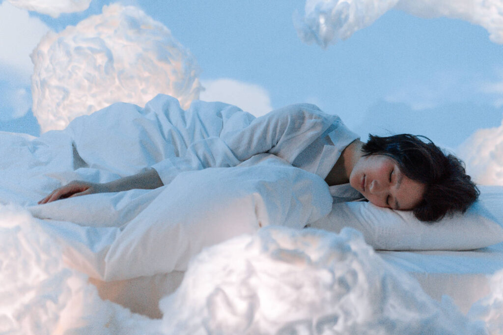 woman sleeping peacefully in a soft bed among the clouds
